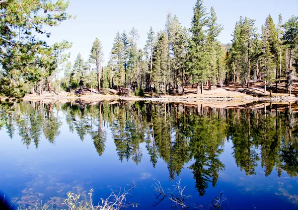 Flat water reflective blue mountain lake — Stock Photo, Image