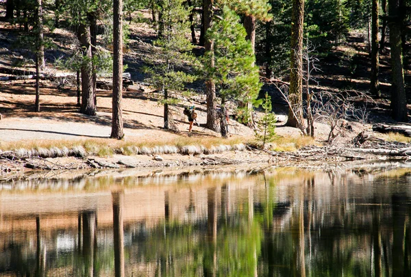 Senderistas reflectantes de montaña junto al lago —  Fotos de Stock