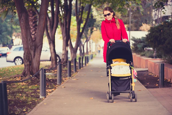 Urban Mother mit ihrem Baby auf einer Fahrt in den Straßen der Stadt. — Stockfoto