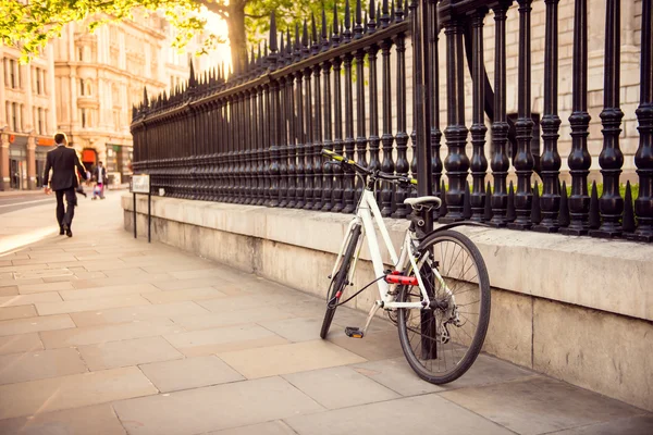 Witte fiets geparkeerd in de stad. — Stockfoto