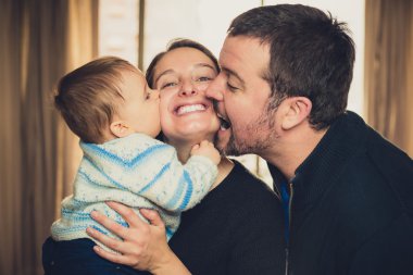 Güzel genç aile. Baba ve oğul anneyi öpüşme