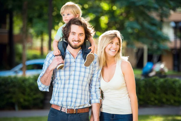 Junge schöne glückliche Familie im Park — Stockfoto