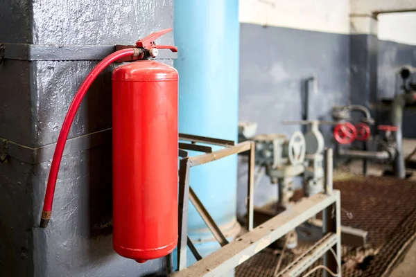 Fire extinguisher equipment in factory for fire protection system. carbon dioxide Fire extinguisher with pressure gauge on wall of production room. Concept of fire safety means of fighting fires.