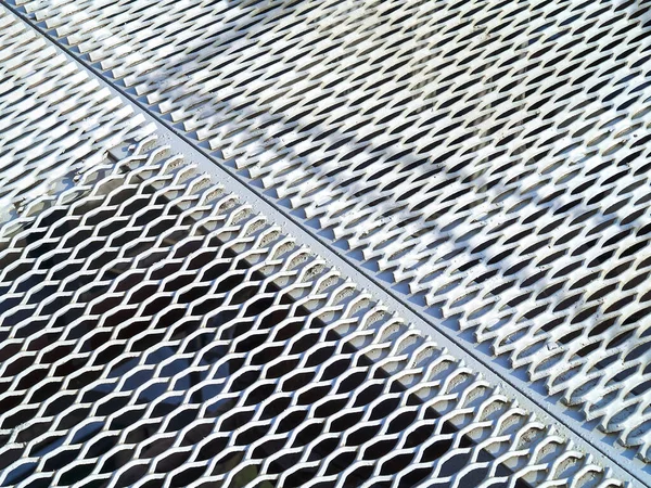 Perforated metal sheet stamping plates texture angled view. Made through metal stamping sheet metal manufacturing lightweight elements to combine loadbearing structural strength, functionality.