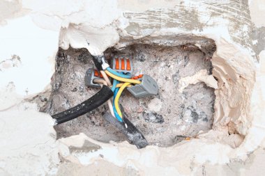 Beton duvarın içindeki delik ve güç kablolarını birleştirmek, yeniden yapılanma kavramı. Elektrik kablolarının kurulumu