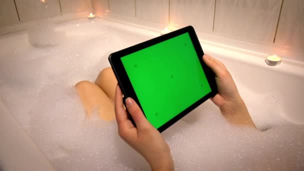 Chica Está Acostada Baño Con Espuma Velas Sostiene Una Tableta — Vídeos de Stock