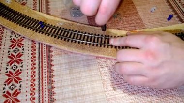 Bir adam demiryolu modeli yapar.