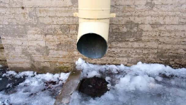 The bottom of a drainpipe with dripping snow melting — Stock Video