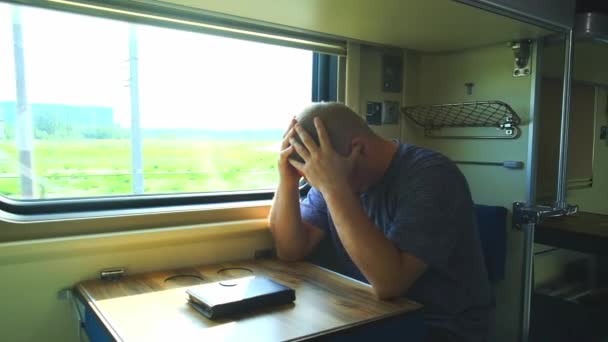 De man heeft hoofdpijn in de trein. — Stockvideo