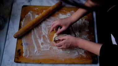 Kadın eli hamurla çalışıyor.