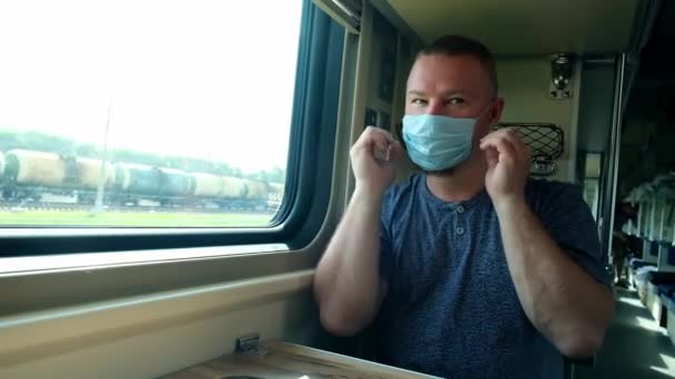 Az ember leveszi az orvosi maszkját a vonaton. — Stock videók