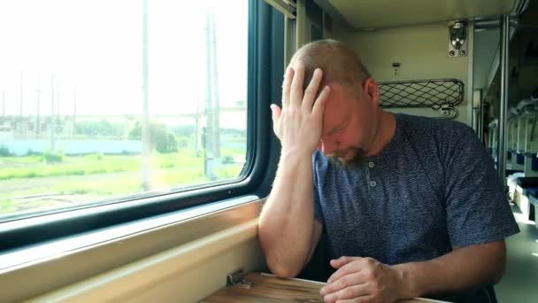 El hombre tiene dolor de cabeza en el tren. — Vídeos de Stock