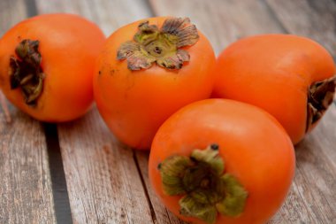 Lotus hurması, ahşap masada tatlı portakal meyvesi.