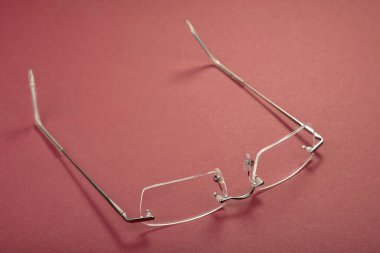 Kırmızı arkaplanda yeni metal gözlük çerçevesi