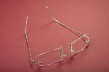 Kırmızı arkaplanda yeni metal gözlük çerçevesi