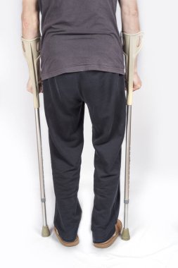 Koltuk değnekli yaşlı adam arkadan.