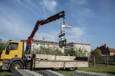 Kamyondan vinçle palet boşaltılıyor.