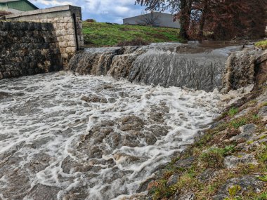 Şiddetli yağmurun ardından küçük bir şehir deresi güçlü bir nehre dönüşüyor.