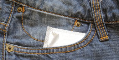 Kot pantolonun cebindeki prezervatifler. Cinsel yolla bulaşan enfeksiyonları önlemek için prezervatif. Boşluğu kopyala