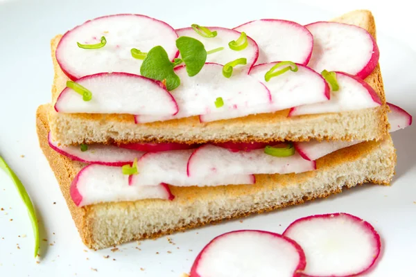 Toast mit frisch gehackten Radieschen und grünen Kräutern auf dem weißen Teller. Gesundes Frühstück. Sandwich mit Gemüse. Nahaufnahme — Stockfoto