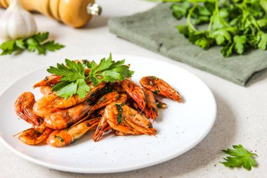 Beyaz arka planda ızgara karides, maydanoz ve karabiber..