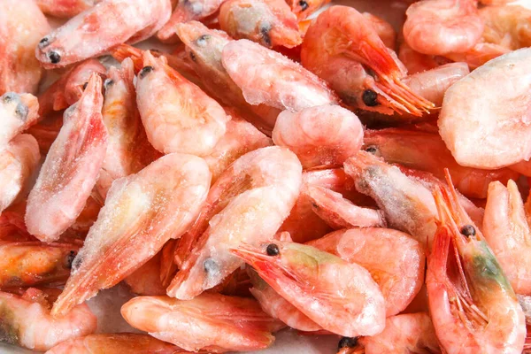 Close-up of a pile of frozen shrimps. No cleaned shrimp. Seafood background. — Stock Photo, Image