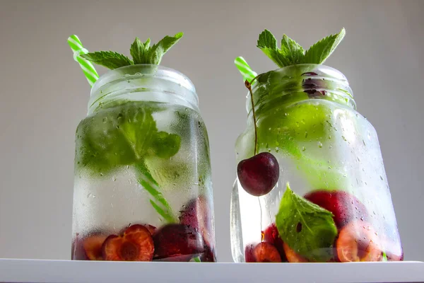 Cold drinks in small bottles. Cherries mint lemonade. Mojito coctail. — Stock Photo, Image