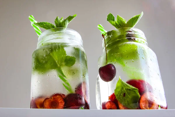 Cold drinks in small bottles. Cherries mint lemonade. Mojito coctail. — Stock Photo, Image