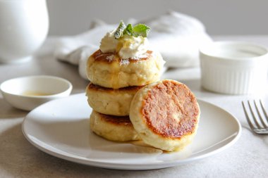 Beyaz tabakta bal ve kremalı tatlı peynirli krep. Ev yapımı peynirli kek tarifi. Yüksek kalite fotoğraf