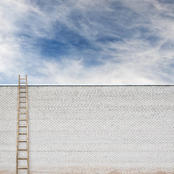 Blå himlen bakom den stora väggen med en trä stege — Stockfoto