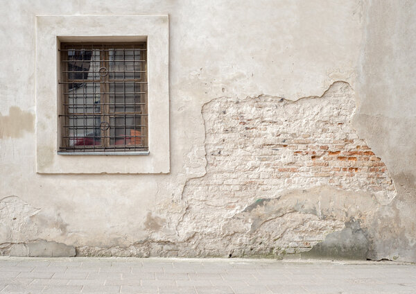 abandoned cracked brick wall with a window
