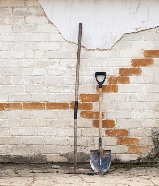 Shovel and rake near the wall — Stock Photo, Image