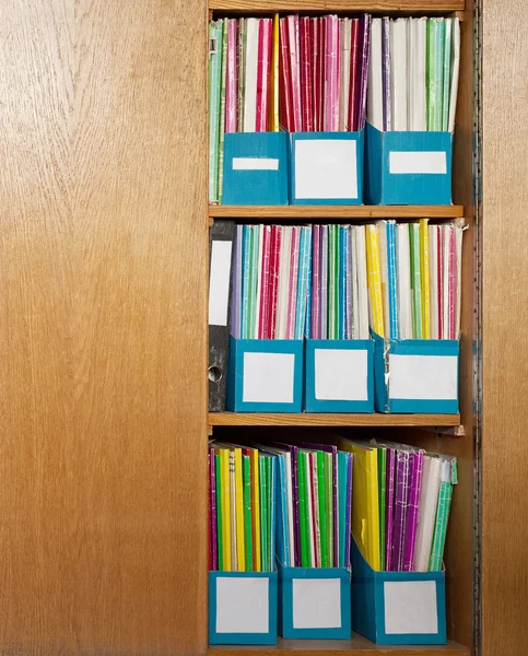 Colour file folders in office cupboard Royalty Free Stock Photos