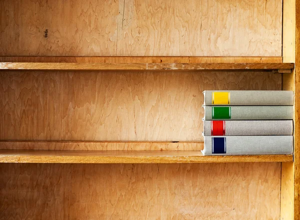 Čtyři nové knihy na dřevěné polici — Stock fotografie