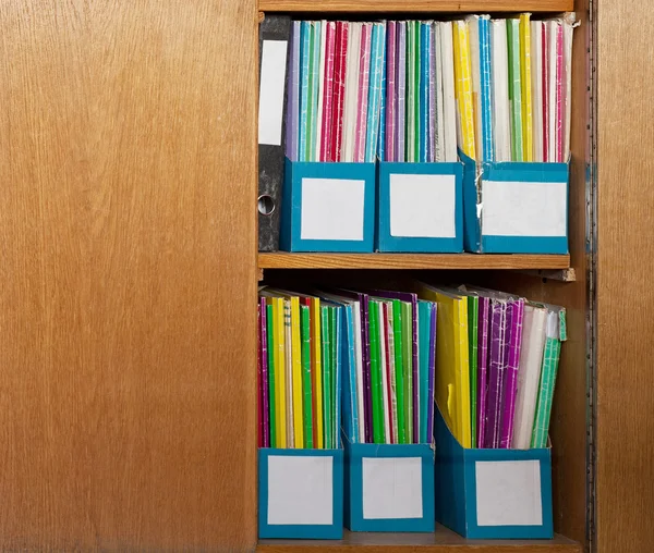 Colour file folders in office cupboard Royalty Free Stock Images