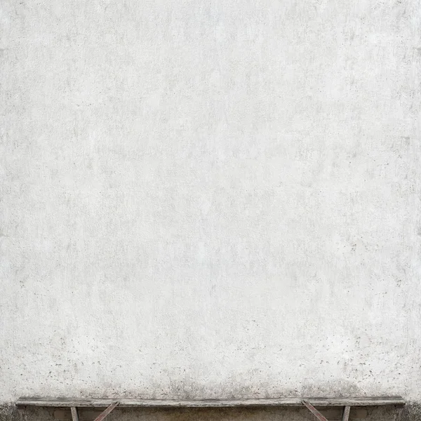 Скамейка возле стены — стоковое фото