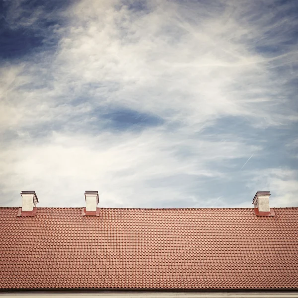 Molnig himmel och tegeltak topp — Stockfoto