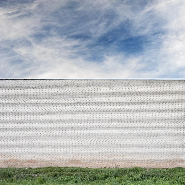 Blue sky with clouds behind the huge wall — Stock Photo, Image