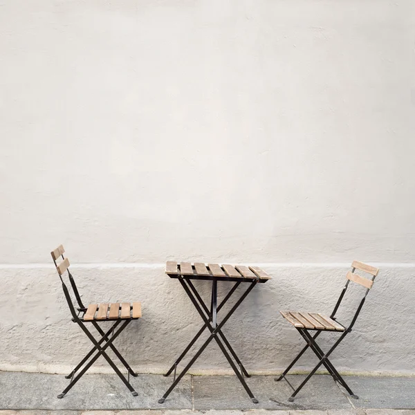 Tisch und zwei Stühle an der Wand Stockfoto