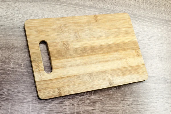 Placa de corte de madeira velha na mesa — Fotografia de Stock