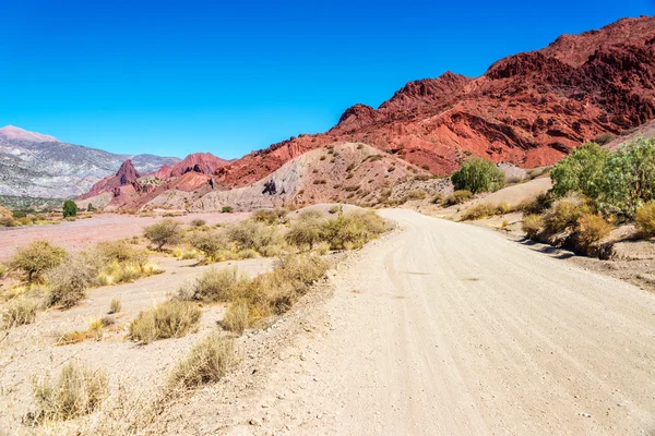 Polní cesta a červené Desert Hills v Bolívii — Stock fotografie
