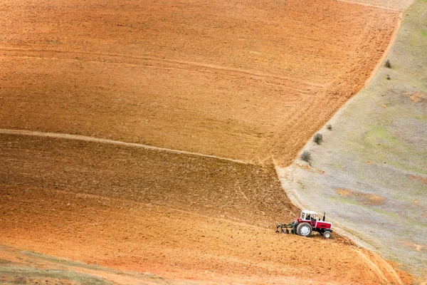 Trekker ploegt een veld — Stockfoto