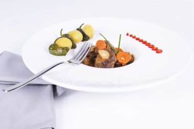 Seçici bir odak noktası ve hafif arka planda çatalı olan süslü bir tabak sığır eti yahnisini kapat. Geleneksel ve sağlıklı gıda konsepti.