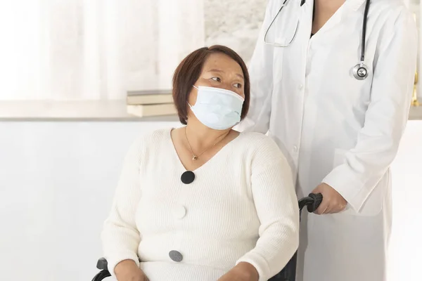 Genç Bir Kadın Doktor Cerrahi Maske Takan Olgun Bir Asyalı — Stok fotoğraf