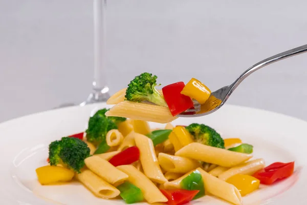 선택적 인 초점으로 파스타 샐러드 접시 위에 파스타와 야채를 올려 놓은 포크를 닫는다. 건강에 좋은 음식과 파스타 개념. — 스톡 사진