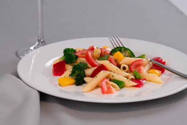 Επιλεκτική εστίαση και κοντά σε νόστιμα ζυμαρικά και λαχανικά που αναζητούν σε ένα πιάτο σε ένα τραπέζι. Υγιεινά τρόφιμα και ζυμαρικά. — Φωτογραφία Αρχείου
