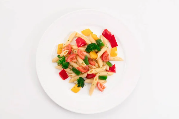 Horní pohled na lahodný talíř s čerstvě uvařenými těstovinami a zeleninou na lehkém pozadí. Zdravé jídlo a těstoviny koncept. — Stock fotografie