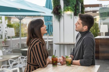Genç bir çift bar terasında konuşuyor.
