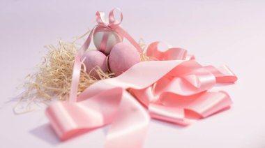 Pembe kurdeleli bir yuvada paskalya yumurtaları