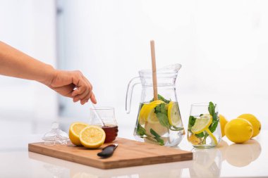 Bir kavanoz limon ve nane ile el ele tutuşan bal